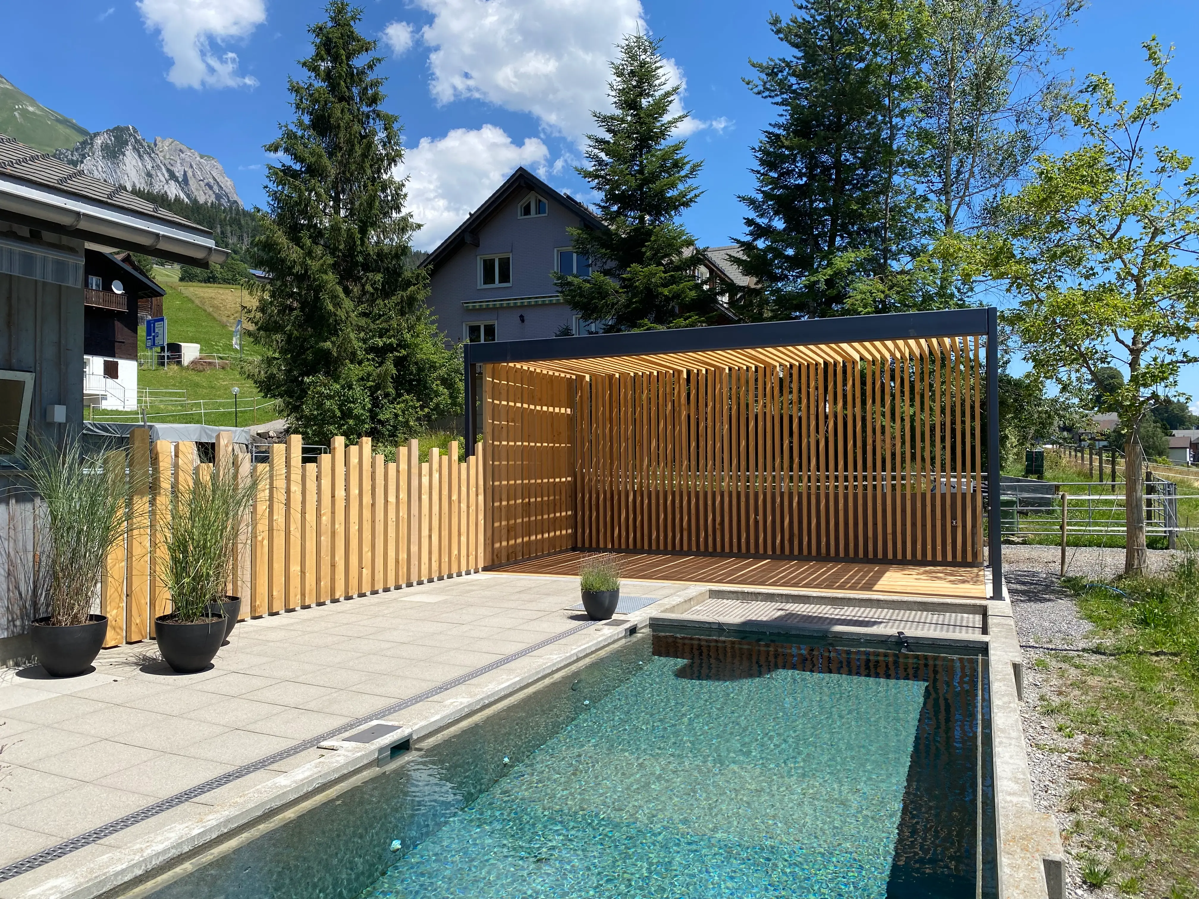 Gebaute Holzpergola mit Pool in einem alpinen Garten im Toggenburg.