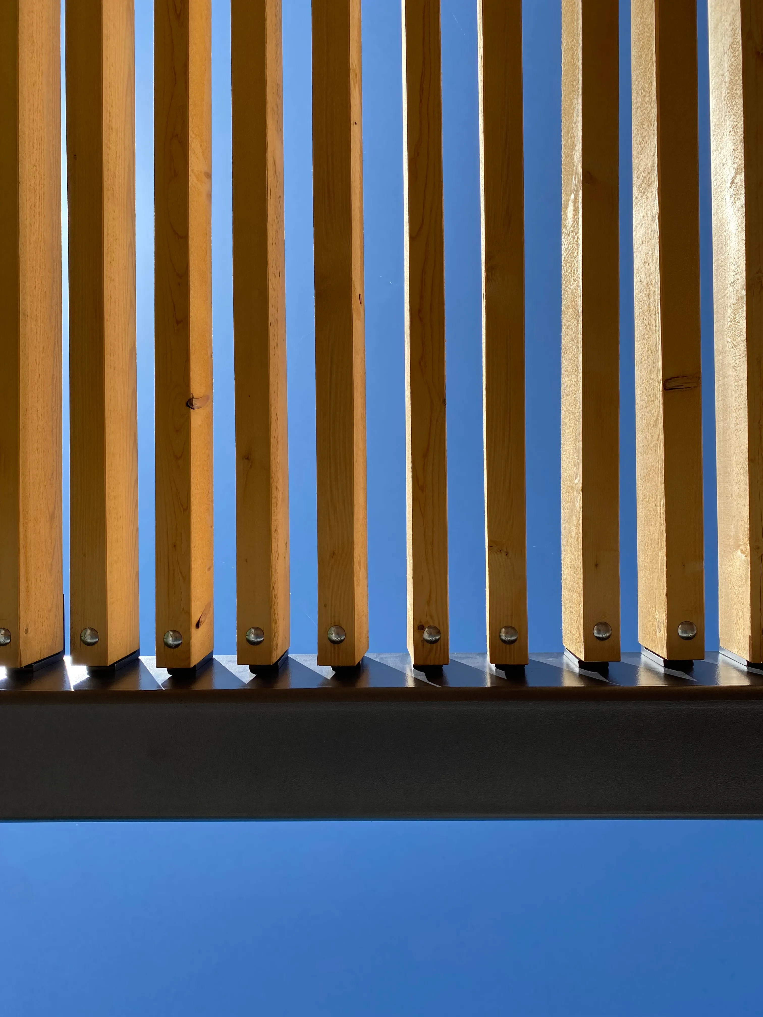Detail der Holzlattung, die Nähe zulässt und dennoch eine Grenze bildet.